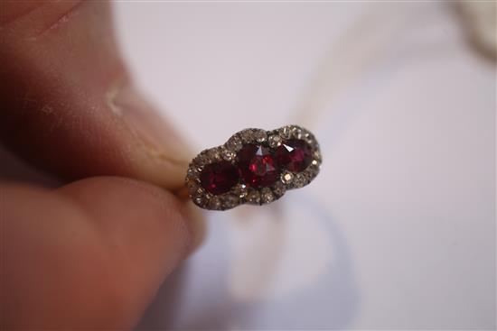 A gold, ruby and diamond triple cluster ring, size K.